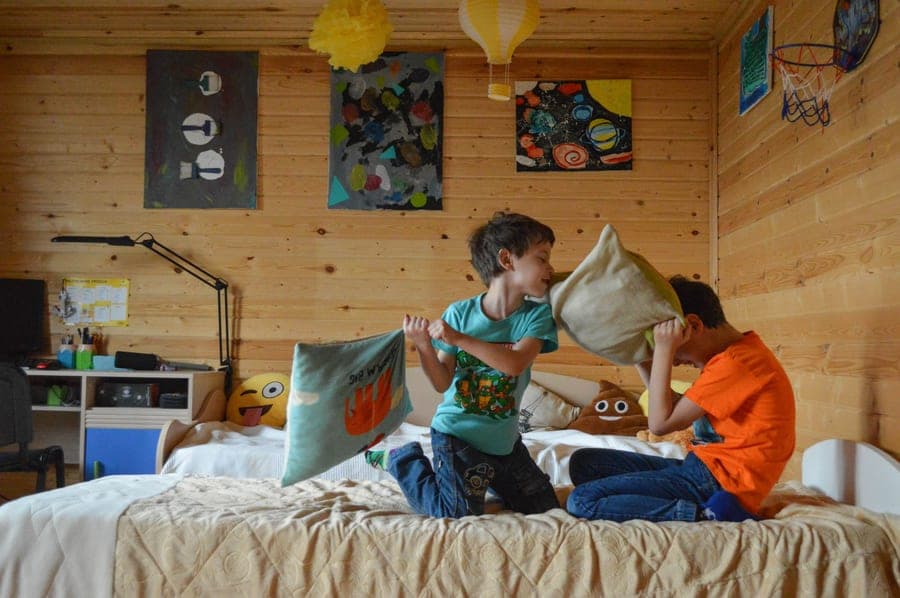 A neatly made child's bed with colorful pillows