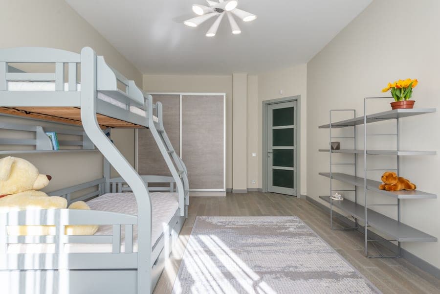 A wooden bunk bed with a ladder in a child's bedroom