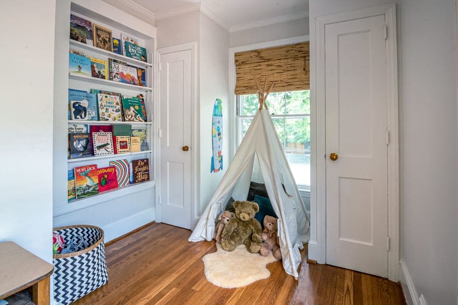 A bookshelf holding children's books in a bedroom