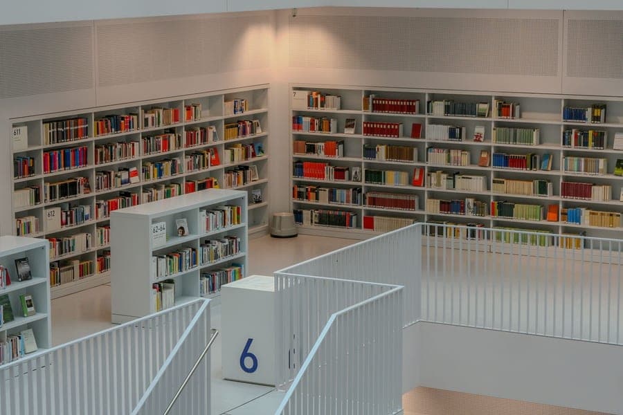 A white desk with shelving above it against a wall