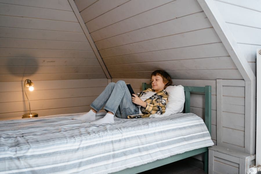 A wooden guardrail on the side of a child's bed