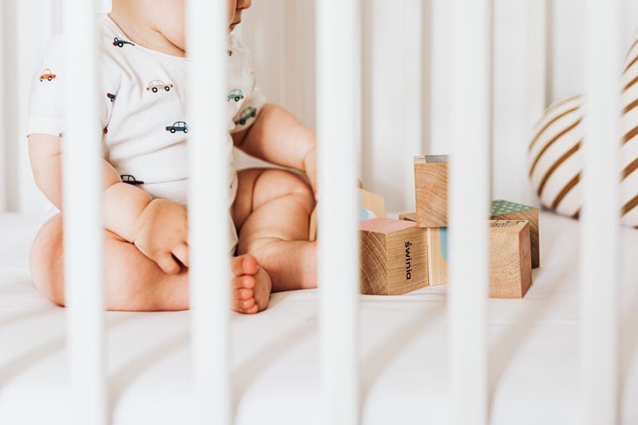 A white wooden crib in a nursery